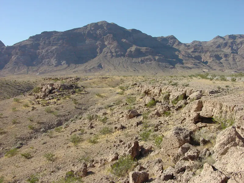 Caliche caprock and rocky terrain in an arid desert landscape.